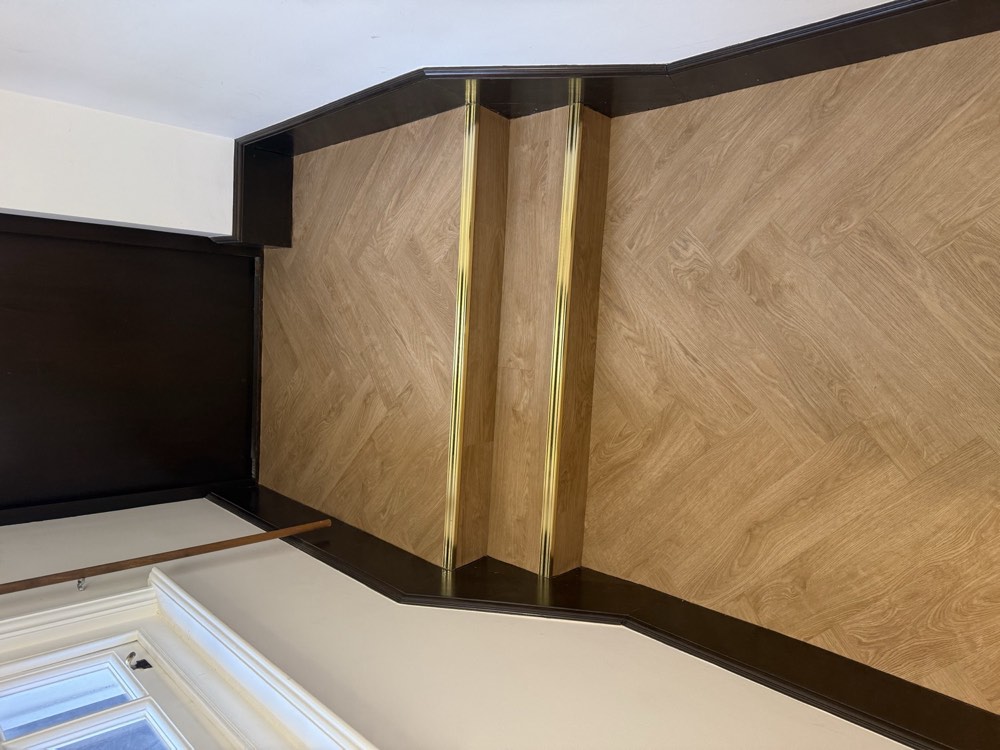 Herringbone flooring on stairs with brass nosings